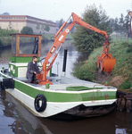 846128 Afbeelding van een medewerker van de provincie Utrecht in een speciaal vaartuig voor het onderhouden van oevers ...